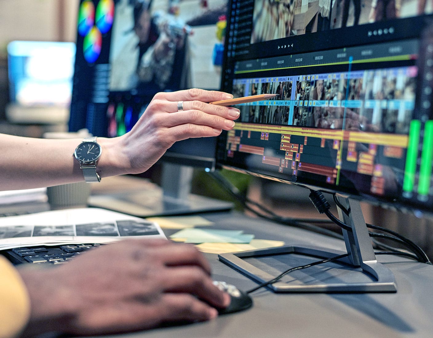 Two individuals collaborate on a computer screen displaying various graphics and analytical data.